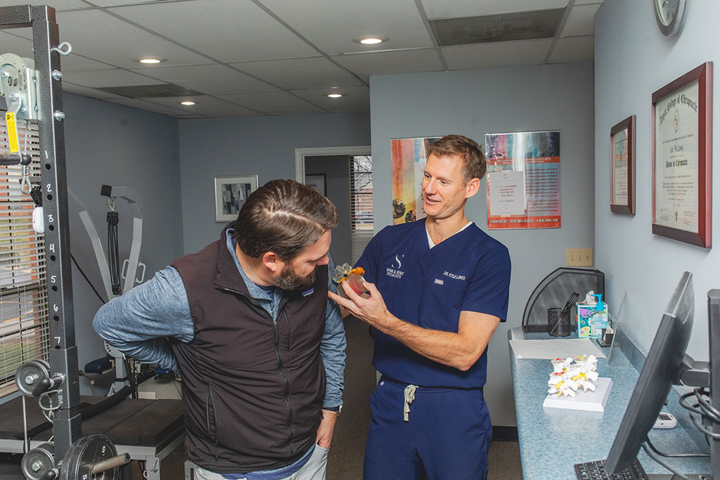 Dr. Longo working with male patient to correct poor posture