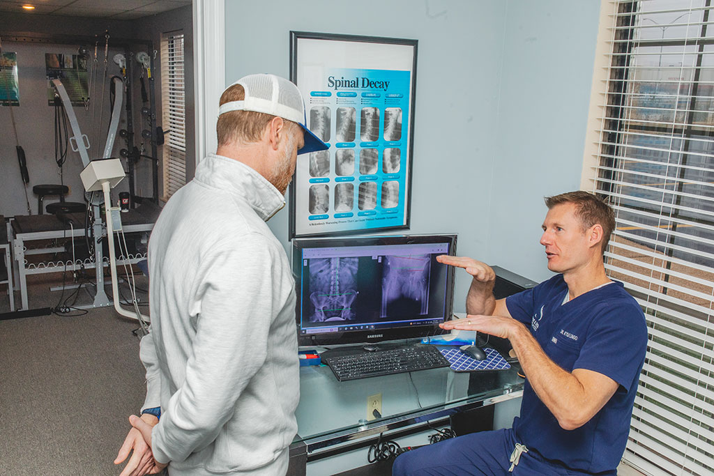 Dr. Longo adjusting the back of a young man during chiropractic treatment for back pain